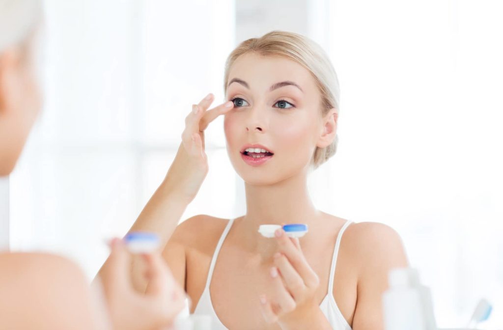 Woman inserting contact lenses to help control her myopia symptoms