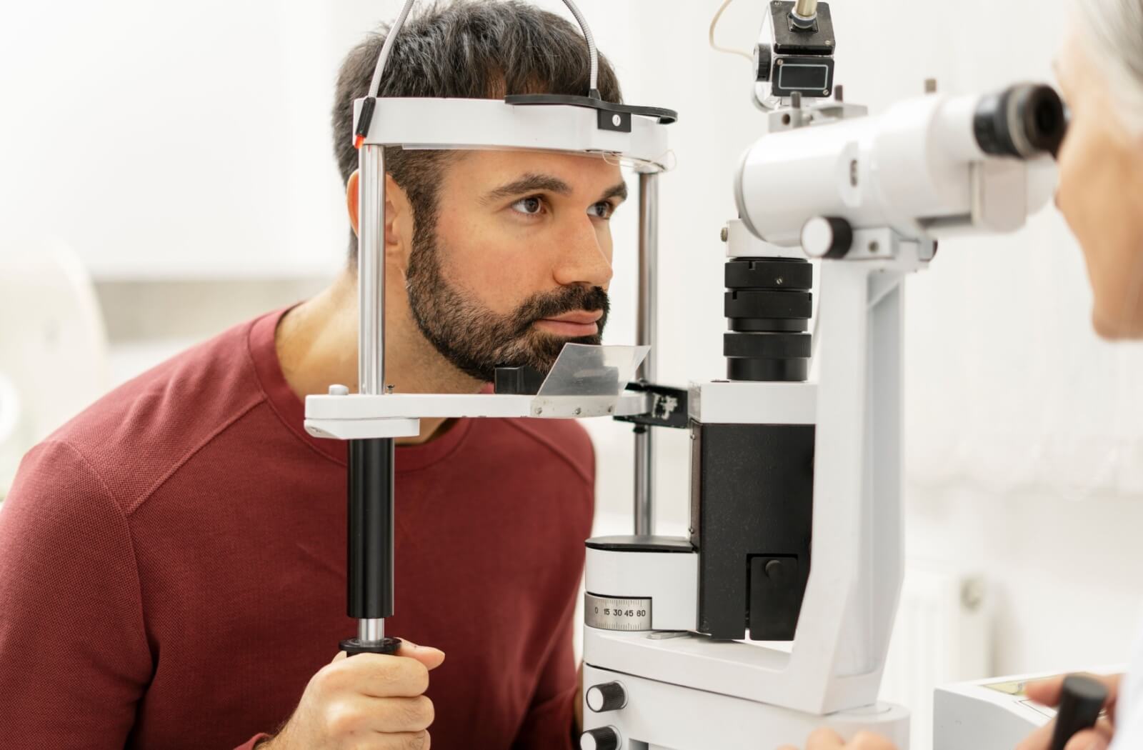 An adult getting a comprehensive eye exam as part of their eye care routine.