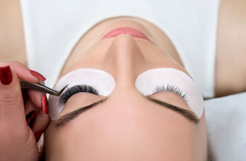 An image of an adult getting eyelash extensions put on by a trusted professional.
