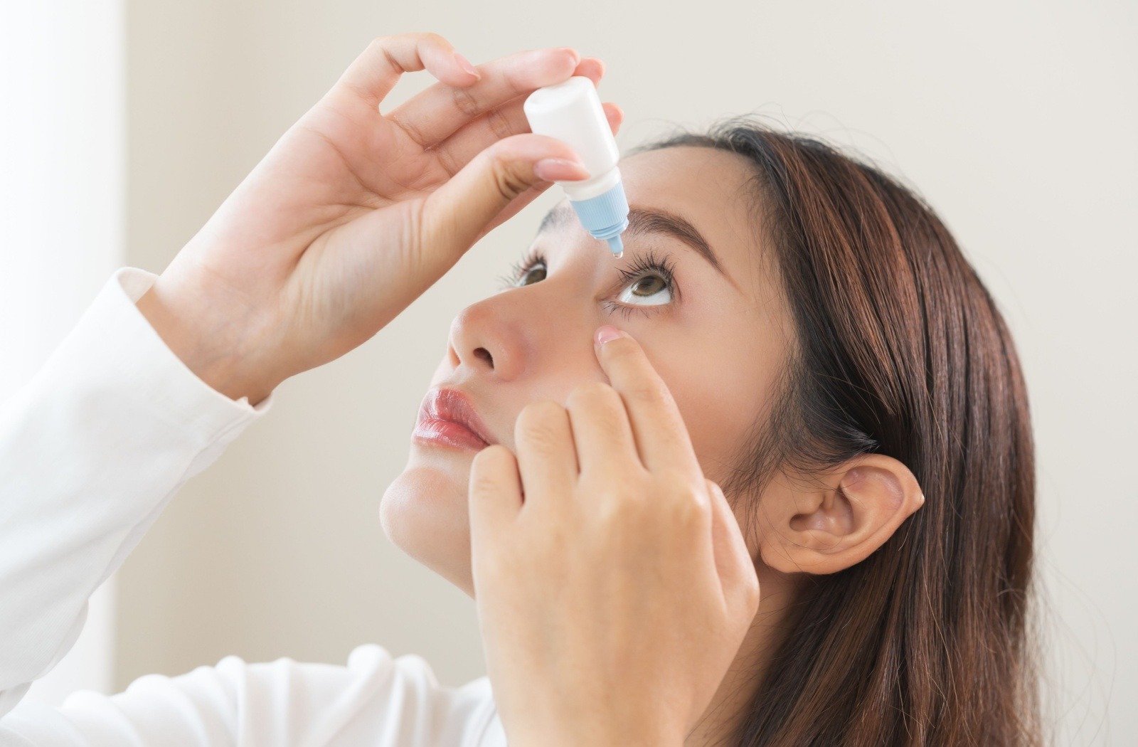 Adult using eyedrops to alleviate dry eye symptoms